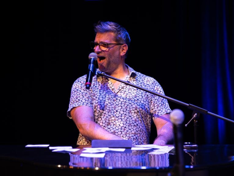 Adam with Black & White Dueling Pianos singing a song